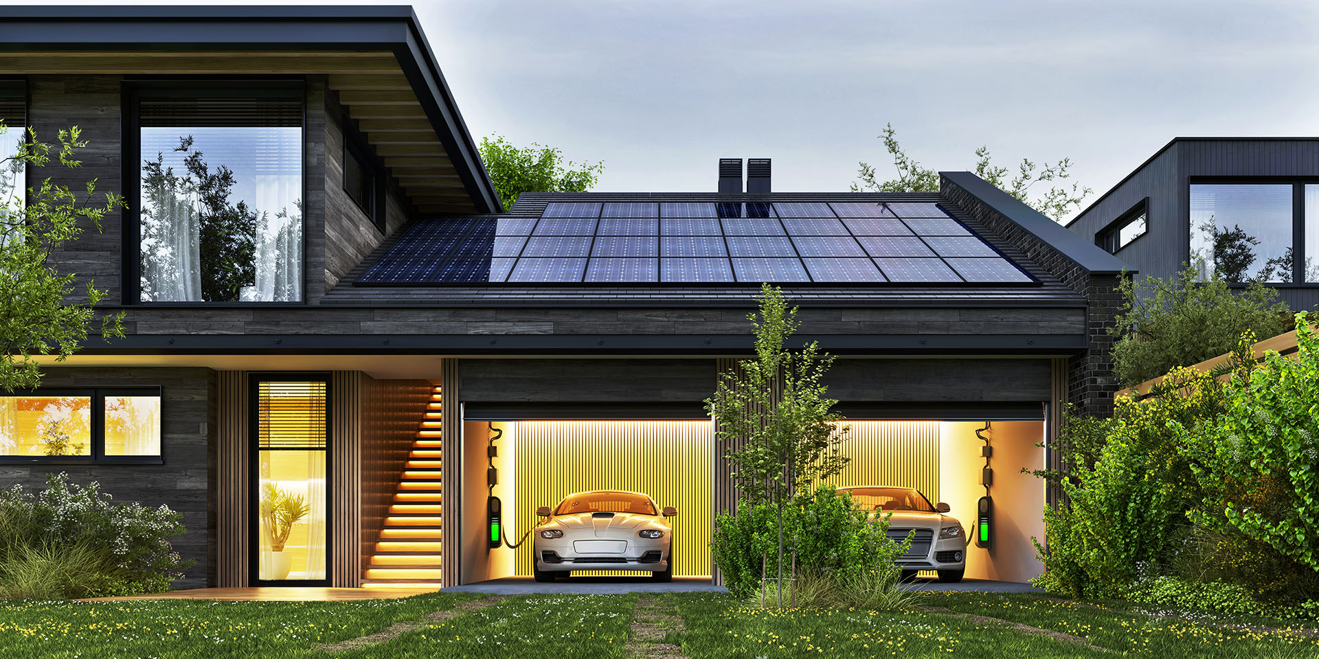 Modernes Einfamilienhaus mit Photovoltaikanlage auf dem Dach und beleuchteter Doppelgarage